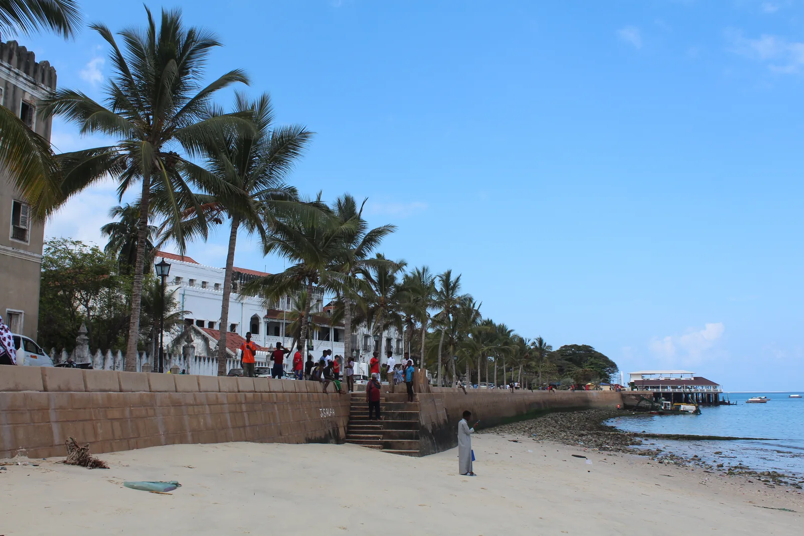 A frente ribeirinha de Stone Town, em Zanzibar, com edifícios antigos e barcos ao longo da costa